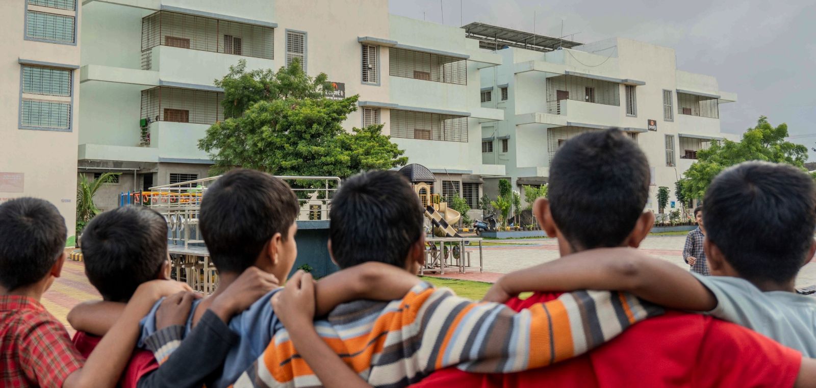 Children at Snehwan with the campus buildings behind them
